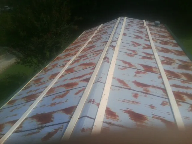 Rusted metal roof panels with new wood purlins before replacement — Storm Damage Roof Repair in Dimondale by Roofing Brothers